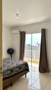 a bedroom with a bed and a balcony at Residencial Da Cal in Torres