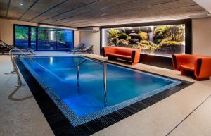 een groot zwembad met oranje ligstoelen en een kamer bij Hotel Sercotel Plana Onda in Onda