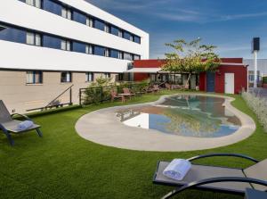 een hotelterrein met een zwembad voor een gebouw bij Hotel Sercotel Plana Onda in Onda