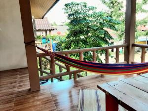 a hammock on a balcony with a view of a yard at Central Essence-200m beachKoh Phangan west coast in Haad Chao Phao