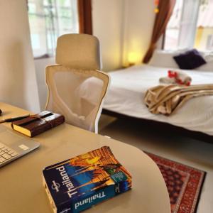 a table with a book on a table with a bed at Central Essence-200m beachKoh Phangan west coast in Haad Chao Phao +1 photo
