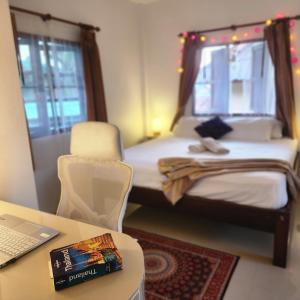 a small room with a bed and a desk with a laptop at Central Essence-200m beachKoh Phangan west coast in Haad Chao Phao