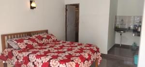 a bedroom with a bed with a red and white blanket at Oak Hill Cottage in Mussoorie