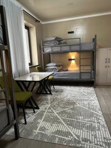 a bedroom with bunk beds and a table and chairs at Friends in Osh