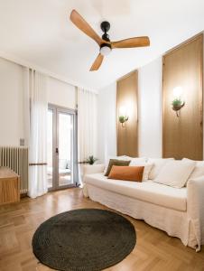 a living room with a white couch and a ceiling fan at Tree Olive Athens in Athens