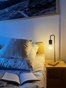 un letto con un libro aperto e una lampada su un tavolo di Apartament "Na Górskim Szlaku" Rabka-Zdrój a Rabka-Zdrój