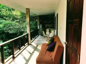 - une terrasse couverte avec un canapé et une table sur un balcon dans l'établissement Feel Home, à Hinkong