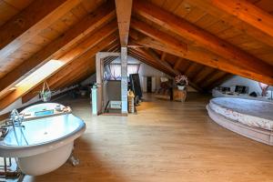 a bathroom with a tub and two beds in a attic at Host Monti del Sole in Meano