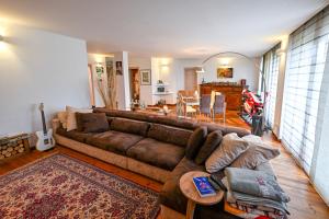 a living room with a brown couch and a table at Host Monti del Sole in Meano +32 photos