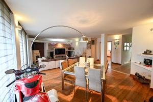 a living room and dining room with a table and a motorcycle at Host Monti del Sole in Meano