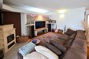 a living room with a couch and a television at Host Monti del Sole in Meano