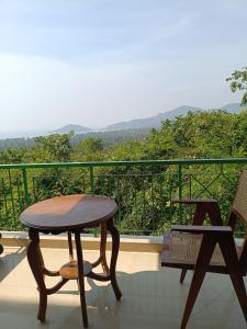 a table and chairs on a balcony with a view at Namaste sea view apartment in Canacona