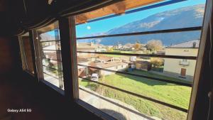 een raam met uitzicht op een berg bij La Corte del Glicine in Villa di Tirano