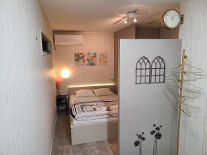 a bedroom with a bed and a clock on the wall at Greci Art Tokyo グレーチアート東京 in Tokyo +48 photos