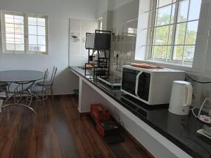 een keuken met een aanrecht met een magnetron en een tafel bij Viceroy Inn Homestay in Ernakulam