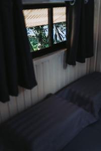 une chambre avec un lit et une fenêtre avec des rideaux dans l'établissement Dedaun Homestay, à Tamparuli