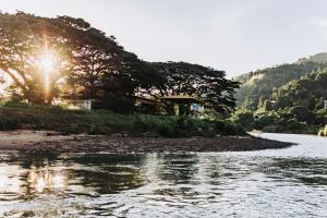a view of a river with the sun shining at Dedaun Homestay in Tamparuli