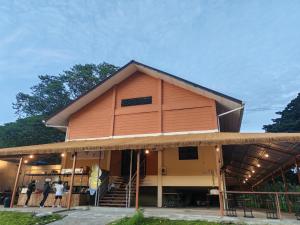 Un bâtiment avec des personnes debout à l'extérieur dans l'établissement Dedaun Homestay, à Tamparuli