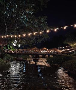 un puente con luces sobre un río por la noche en Kanatal stay, en Dhanaulti