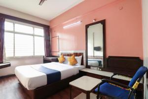 una stanza d'albergo con un letto e una sedia di Super Hotel O Archana Inn a Bangalore Altre 34 foto