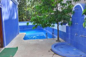a blue tiled swimming pool with a tree in it at Hotel Seagull in Calangute