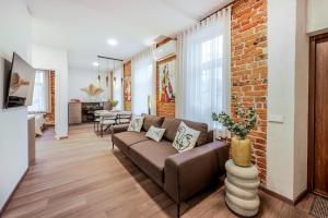 ein Wohnzimmer mit einer Couch und einer Ziegelwand in der Unterkunft Center Gallery Apartment in Kaunas