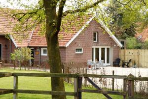 een stenen huis met een hek ervoor bij B&B Bergheide in Baexem