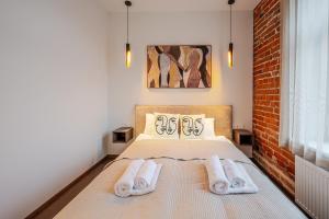 ein Schlafzimmer mit einem Bett, auf dem zwei Handtücher liegen in der Unterkunft Center Gallery Apartment in Kaunas