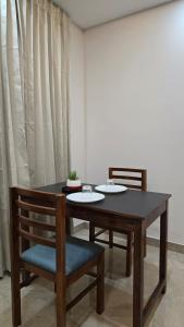 uma mesa de jantar com 2 cadeiras e uma mesa e cadeira em Munderi Green Mounts - Premium Pool Stay Near Kalpetta, Wayanad em Kalpatta