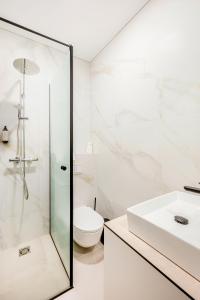 ein Badezimmer mit Dusche, Toilette und Waschbecken in der Unterkunft Center Gallery Apartment in Kaunas + 37 Fotos