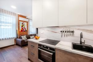 a kitchen with a sink and a stove top oven at Center Gallery Apartment in Kaunas