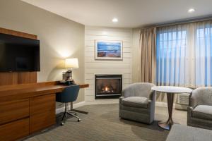 een hotelkamer met een open haard, een bureau en stoelen bij Anchorage by the Sea in Ogunquit