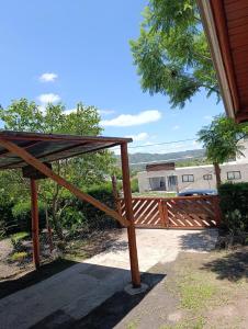 ein Holztor zu einem Haus mit einem Dach in der Unterkunft Cabaña villa ediht in Villa Parque Siquiman