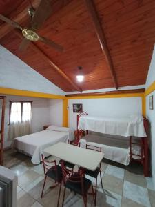 ein Zimmer mit zwei Betten und einem Tisch und Stühlen in der Unterkunft Cabaña villa ediht in Villa Parque Siquiman