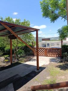 eine hölzerne Pergola mit einem Holzzaun in der Unterkunft Cabaña villa ediht in Villa Parque Siquiman