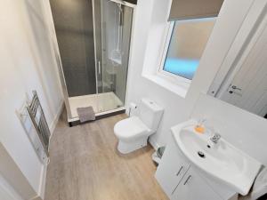a white bathroom with a toilet and a sink at Regent Circus Apartments in Swindon