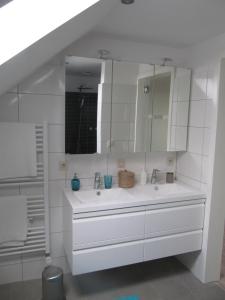 Baño blanco con lavabo y espejo en B&B Bodegem en Dilbeek