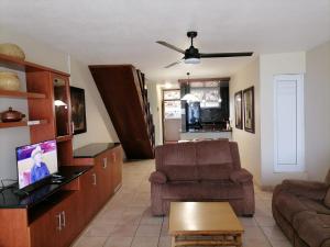 un salon avec un canapé et une chaise dans l'établissement Inyoni Rocks Cabanas 15, à Amanzimtoti