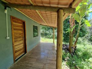 een veranda van een huis met een houten deur bij Suíte de Marcio in Itacaré