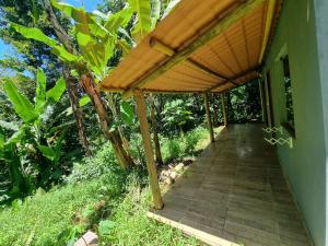 een houten loopbrug naar een huis met een pergola bij Suíte de Marcio in Itacaré