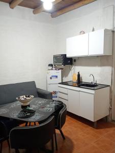 eine Küche mit einem Tisch und eine Küche mit einer Spüle und einem Herd in der Unterkunft Monoambiente Nuevo en Barreal in Barreal