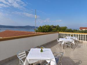 a row of tables and chairs on a balcony at Pansion Danilo by the sea in Krmčina