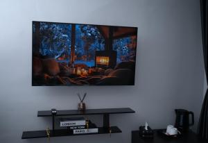 a living room with a tv hanging on the wall at Hôtel Sofiane in Paris