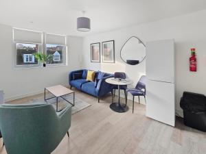 a living room with a blue couch and a table at Regent Circus Apartments in Swindon