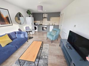 a living room with a blue couch and a table at Regent Circus Apartments in Swindon