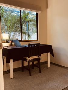 a table with a laptop on it with a chair at Hotel Daleese in Uvita