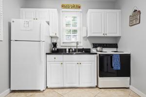 een keuken met witte kasten en een witte koelkast bij Prime Downtown Location - Truman Little Cozy Cottage in Key West