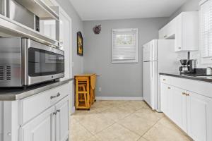 een keuken met witte kasten en een magnetron bij Prime Downtown Location - Truman Little Cozy Cottage in Key West +12 foto's