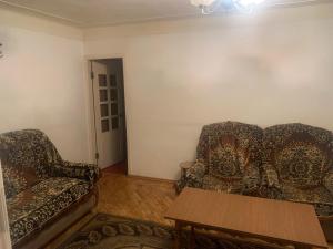 een woonkamer met twee stoelen en een tafel bij Джермук 3-комнатная квартира in Dzjermoek
