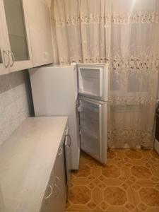 a small kitchen with a white refrigerator in it at Джермук 3-комнатная квартира in Jermuk